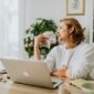 Seorang wanita modern sedang fokus meninjau laporan keuangan di laptopnya, menunjukkan dedikasinya dalam mengelola aset demi masa depan yang terencana dengan baik. Gambar ini merefleksikan pentingnya kemandirian finansial bagi perempuan dalam mencapai tujuan hidup mereka.