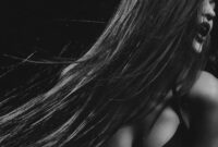 Seorang wanita dengan gaya rambut berlapis lembut yang terinspirasi dari era 90-an namun diperbarui dengan teknik pewarnaan balayage modern, menonjolkan dimensi dan tekstur alami rambutnya. Gaya ini sangat diminati karena memberikan volume tanpa kesan kaku.