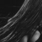 Seorang wanita dengan gaya rambut berlapis lembut yang terinspirasi dari era 90-an namun diperbarui dengan teknik pewarnaan balayage modern, menonjolkan dimensi dan tekstur alami rambutnya. Gaya ini sangat diminati karena memberikan volume tanpa kesan kaku.