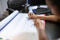 Seorang perempuan sedang menandai kalendernya, menunjukkan kebiasaan melacak siklus haid yang merupakan bagian penting dari pemahaman kesehatan reproduksi. Aktivitas ini membantu mengidentifikasi pola dan potensi masalah sejak dini.