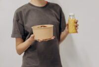 Seorang remaja perempuan sedang menikmati semangkuk salad buah segar, menunjukkan pentingnya asupan nutrisi seimbang untuk mendukung aktivitas sehari-hari dan tumbuh kembangnya.