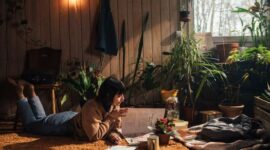Seorang wanita menikmati momen tenang sambil membaca buku di sofa, menggambarkan pentingnya meluangkan waktu untuk diri sendiri demi menjaga kesehatan mental. Pemandangan ini menunjukkan bagaimana aktivitas sederhana dapat menjadi jeda yang berarti dari rutinitas harian.
