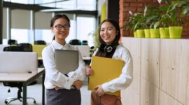 Seorang wanita profesional Indonesia tersenyum penuh percaya diri di sebuah acara jaringan, menunjukkan pentingnya koneksi dalam perjalanan karier. Ekspresi optimis ini mencerminkan semangat juang dan ambisi yang diperlukan untuk mencapai kesuksesan di dunia kerja modern.