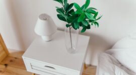 Ilustrasi kamar tidur minimalis dengan dominasi warna netral dan pencahayaan alami, menciptakan suasana tenang yang mengundang relaksasi. Desain ini menunjukkan bagaimana kesederhanaan furnitur dan penataan yang rapi dapat menghasilkan ruang yang elegan sekaligus sangat fungsional.
