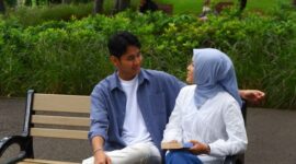 Seorang perempuan berhijab mengenakan paduan tunik panjang berwarna pastel dengan celana kulot lebar, tas selempang minimalis, dan hijab pashmina polos yang memberikan kesan santai namun tetap elegan. Penampilan ini merefleksikan tren OOTD hijab 2026 yang mengedepankan kenyamanan dan gaya personal.