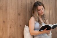 Seorang wanita menikmati momen tenang membaca buku di rumah, menunjukkan pentingnya meluangkan waktu untuk diri sendiri demi menjaga kesehatan mental di tengah kesibukan. Suasana nyaman ini mencerminkan ide me time yang efektif tanpa perlu keluar dari hunian pribadi.