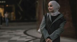 Seorang wanita mengenakan busana hijab dengan warna pastel lembut dan potongan longgar yang elegan, mencerminkan tren OOTD hijab 2026. Tampilan ini memadukan kenyamanan dan gaya modern untuk aktivitas sehari-hari di perkotaan.