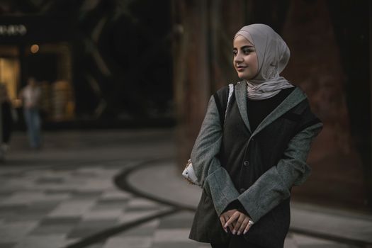 Seorang wanita mengenakan busana hijab dengan warna pastel lembut dan potongan longgar yang elegan, mencerminkan tren OOTD hijab 2026. Tampilan ini memadukan kenyamanan dan gaya modern untuk aktivitas sehari-hari di perkotaan.