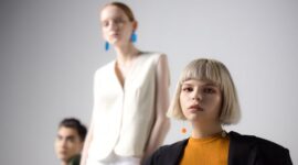 Seorang wanita berjalan dengan percaya diri mengenakan setelan berwarna hijau limau yang mencolok, dipadukan dengan tas tangan mini dan sepatu platform, merepresentasikan tren fashion wanita terkini di tahun 2026 yang mengedepankan warna vibran dan siluet berani.