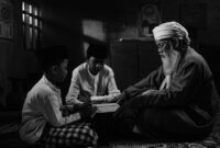 Seorang nenek yang penuh kasih sedang membacakan cerita rakyat Indonesia kepada cucunya, menggambarkan transmisi kearifan lokal dari generasi ke generasi di tengah keindahan tradisi. Gambar ini menangkap esensi kehangatan keluarga dan pentingnya melestarikan warisan budaya melalui kisah-kisah yang tak lekang oleh waktu.