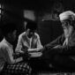 Seorang nenek yang penuh kasih sedang membacakan cerita rakyat Indonesia kepada cucunya, menggambarkan transmisi kearifan lokal dari generasi ke generasi di tengah keindahan tradisi. Gambar ini menangkap esensi kehangatan keluarga dan pentingnya melestarikan warisan budaya melalui kisah-kisah yang tak lekang oleh waktu.