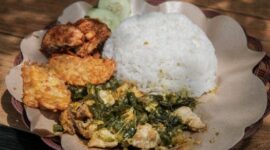 Sebuah hidangan nasi goreng kampung yang disajikan dengan telur mata sapi, kerupuk, dan acar, tampak begitu menggoda selera dengan taburan bawang goreng. Hidangan ini menunjukkan bagaimana makanan rumahan yang sederhana bisa diolah menjadi sajian istimewa yang lezat dan praktis.