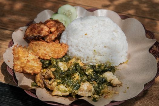 Sebuah hidangan nasi goreng kampung yang disajikan dengan telur mata sapi, kerupuk, dan acar, tampak begitu menggoda selera dengan taburan bawang goreng. Hidangan ini menunjukkan bagaimana makanan rumahan yang sederhana bisa diolah menjadi sajian istimewa yang lezat dan praktis.