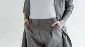 Seorang wanita modern memadukan blazer longgar berwarna krem dengan celana kulot, menunjukkan esensi gaya minimalis adaptif yang nyaman dan elegan. Pilihan busana ini merefleksikan tren fashion 2026 yang mengedepankan keberlanjutan dan fungsionalitas dalam setiap kesempatan.