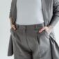 Seorang wanita modern memadukan blazer longgar berwarna krem dengan celana kulot, menunjukkan esensi gaya minimalis adaptif yang nyaman dan elegan. Pilihan busana ini merefleksikan tren fashion 2026 yang mengedepankan keberlanjutan dan fungsionalitas dalam setiap kesempatan.