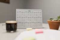 Seorang wanita tengah merencanakan jadwal hariannya menggunakan kalender dan catatan, menunjukkan dedikasi pada manajemen waktu yang terstruktur. Gambar ini merepresentasikan pentingnya perencanaan dan fokus dalam mencapai produktivitas maksimal.