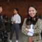Seorang wanita profesional Indonesia berinteraksi dengan rekan kerja di lingkungan kantor modern, menunjukkan semangat kolaborasi dan kepercayaan diri dalam meniti karier. Suasana dinamis ini merefleksikan pentingnya interaksi positif dan dukungan tim dalam mencapai tujuan profesional.