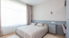 Kamar tidur minimalis dengan dominasi warna netral dan pencahayaan alami yang melimpah, menciptakan suasana tenang dan lapang. Desain ini mengutamakan fungsi esensial dan keindahan sederhana untuk mendukung istirahat yang berkualitas.