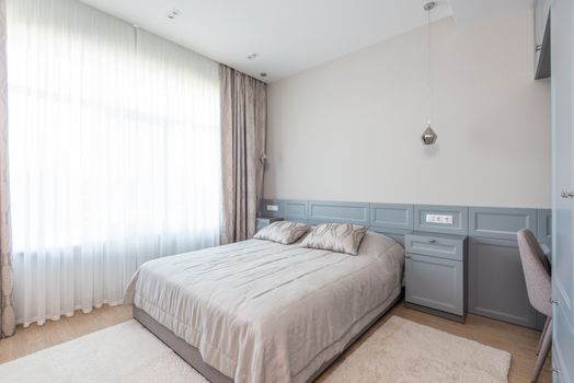 Kamar tidur minimalis dengan dominasi warna netral dan pencahayaan alami yang melimpah, menciptakan suasana tenang dan lapang. Desain ini mengutamakan fungsi esensial dan keindahan sederhana untuk mendukung istirahat yang berkualitas.