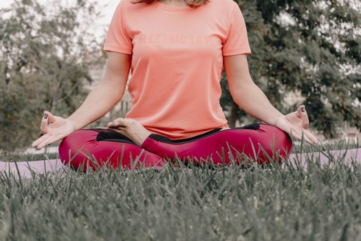 Seorang wanita sedang bermeditasi dengan tenang di tengah hijaunya alam, merefleksikan esensi gaya hidup "slow living" yang menenangkan jiwa dan pikiran dari hiruk pikuk kehidupan. Pemandangan ini menggambarkan ketenangan serta keseimbangan yang bisa dicapai melalui kesadaran penuh terhadap diri sendiri dan lingkungan sekitar.