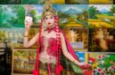 Seorang penutur cerita tradisional dengan busana adat membagikan kisah-kisah legenda rakyat kepada sekelompok anak, menggambarkan bagaimana warisan lisan ini terus dihidupkan dari generasi ke generasi. Pemandangan ini menekankan pentingnya interaksi dan penyampaian cerita secara langsung untuk menjaga kelestarian budaya.