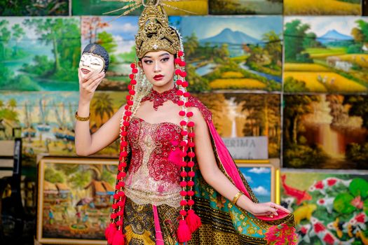 Seorang penutur cerita tradisional dengan busana adat membagikan kisah-kisah legenda rakyat kepada sekelompok anak, menggambarkan bagaimana warisan lisan ini terus dihidupkan dari generasi ke generasi. Pemandangan ini menekankan pentingnya interaksi dan penyampaian cerita secara langsung untuk menjaga kelestarian budaya.