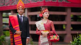 Seorang desainer muda Indonesia sedang menjelaskan inspirasi di balik koleksi busana terbarunya yang menggabungkan motif batik klasik dengan siluet modern, menunjukkan bagaimana warisan budaya dapat menjadi sumber kreativitas tanpa batas.