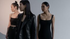 Seorang wanita modern mengenakan busana minimalis elegan dengan siluet longgar dan palet warna netral, mencerminkan salah satu tren utama fashion wanita tahun 2026 yang mengutamakan kenyamanan dan gaya abadi. Detail aksen seperti tas tangan geometris melengkapi tampilan secara apik.