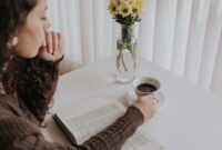Seorang wanita menikmati secangkir teh hangat sambil membaca buku di sofa yang nyaman, menciptakan momen *me time* yang tenang dan menenangkan di tengah kesibukan hari. Gambar ini merefleksikan pentingnya jeda untuk diri sendiri demi menjaga keseimbangan hidup.