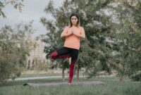 Sebuah piring berisi makanan sehat berwarna-warni di samping seseorang yang sedang melakukan yoga di taman, menggambarkan keseimbangan antara nutrisi dan aktivitas fisik untuk hidup yang lebih sehat.