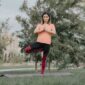 Sebuah piring berisi makanan sehat berwarna-warni di samping seseorang yang sedang melakukan yoga di taman, menggambarkan keseimbangan antara nutrisi dan aktivitas fisik untuk hidup yang lebih sehat.