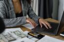 Seorang wanita Indonesia tampak fokus meninjau laporan keuangan di tabletnya, menggambarkan komitmennya dalam mengelola anggaran pribadi untuk mencapai stabilitas finansial. Gambar ini menginspirasi perempuan untuk aktif dalam perencanaan keuangan demi masa depan yang lebih cerah dan mandiri.
