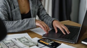 Seorang wanita Indonesia tampak fokus meninjau laporan keuangan di tabletnya, menggambarkan komitmennya dalam mengelola anggaran pribadi untuk mencapai stabilitas finansial. Gambar ini menginspirasi perempuan untuk aktif dalam perencanaan keuangan demi masa depan yang lebih cerah dan mandiri.