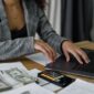 Seorang wanita Indonesia tampak fokus meninjau laporan keuangan di tabletnya, menggambarkan komitmennya dalam mengelola anggaran pribadi untuk mencapai stabilitas finansial. Gambar ini menginspirasi perempuan untuk aktif dalam perencanaan keuangan demi masa depan yang lebih cerah dan mandiri.